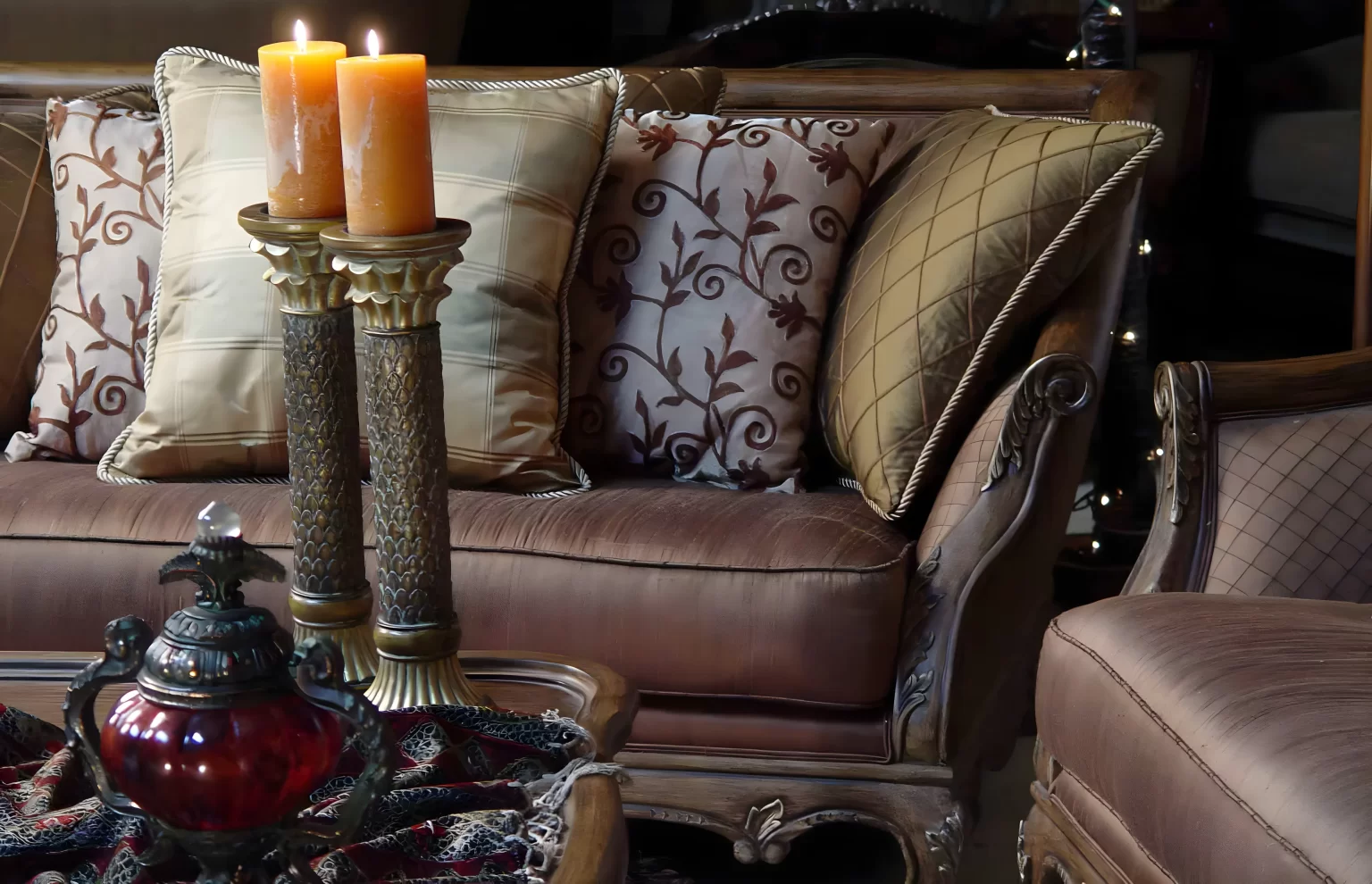 Image of a beautiful sofa behind two candlesticks on a table.